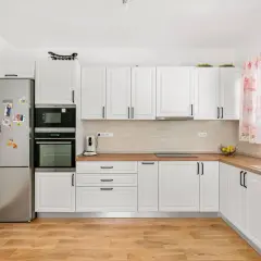Jasny zlew doskonale komponuje się z drewnianym blatem w tej nowoczesnej kuchni.