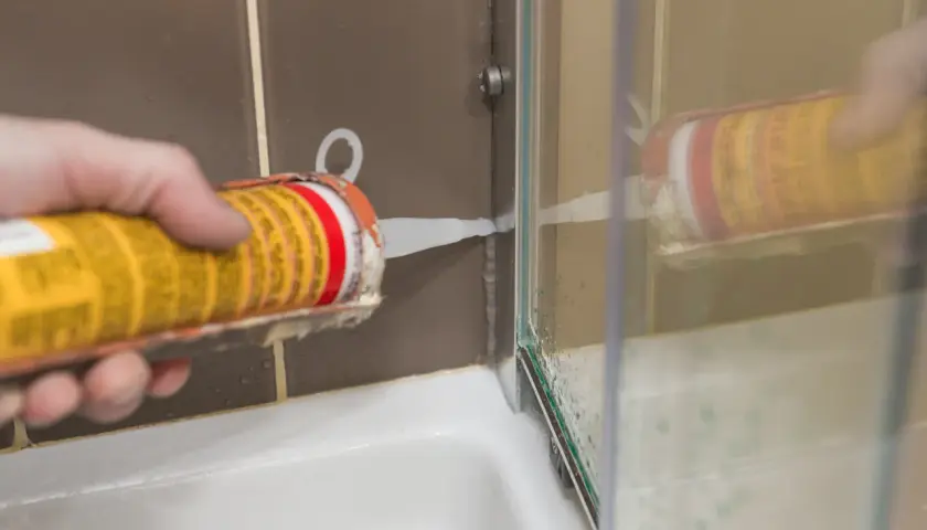 Aplikacja silikonu neutralnego białego do uszczelnienia brodzika prysznicowego.